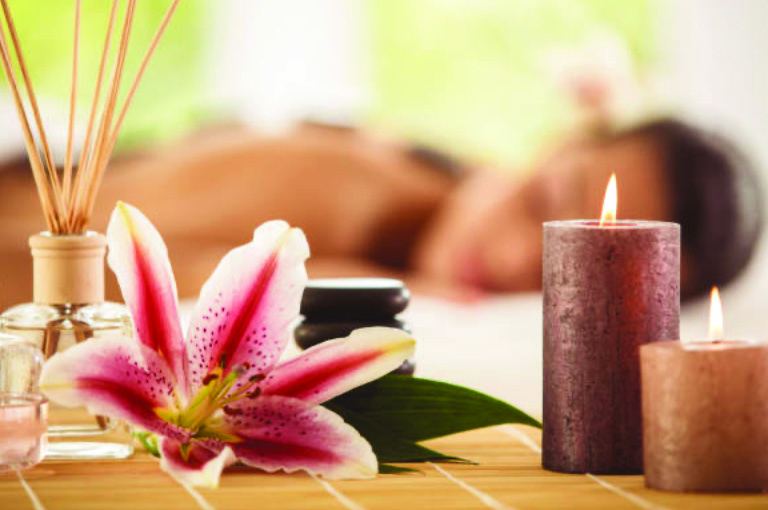 Warm essential oils, candles and lilies in a spa setting